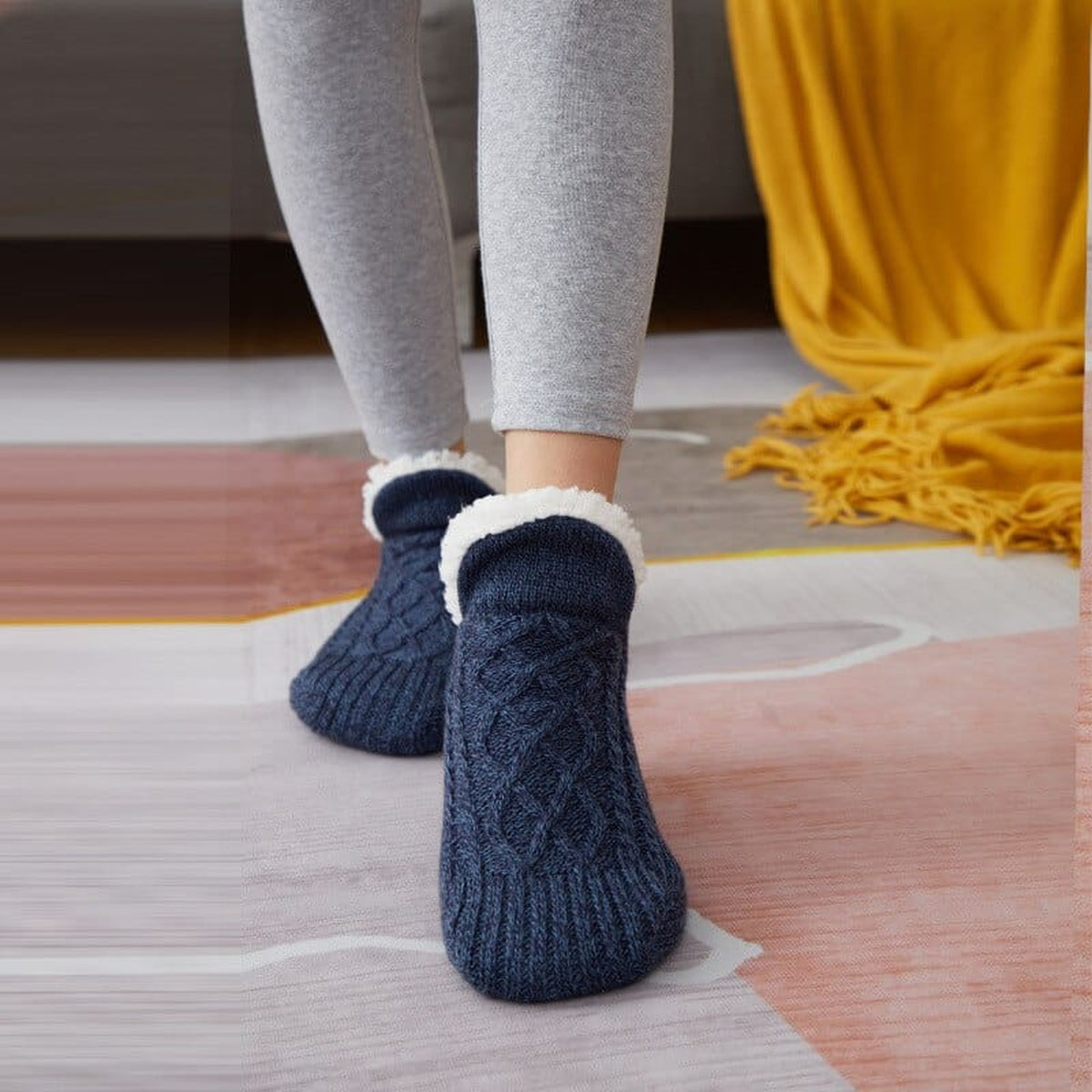 Chaussettes fourrées bleu marine à maille torsadée portées sur un tapis