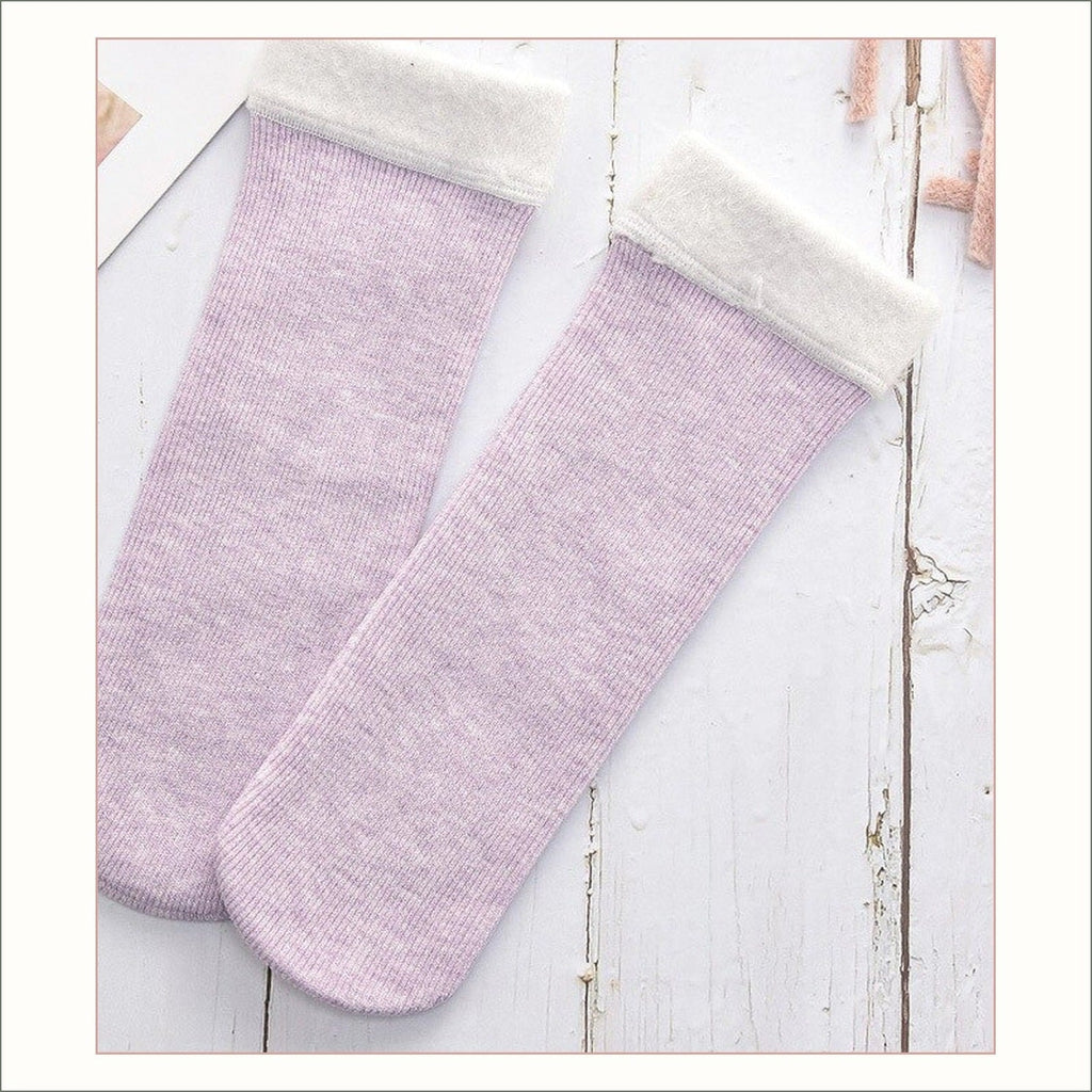 Paire de chaussettes fourrées violettes à revers duveteux posée à plat