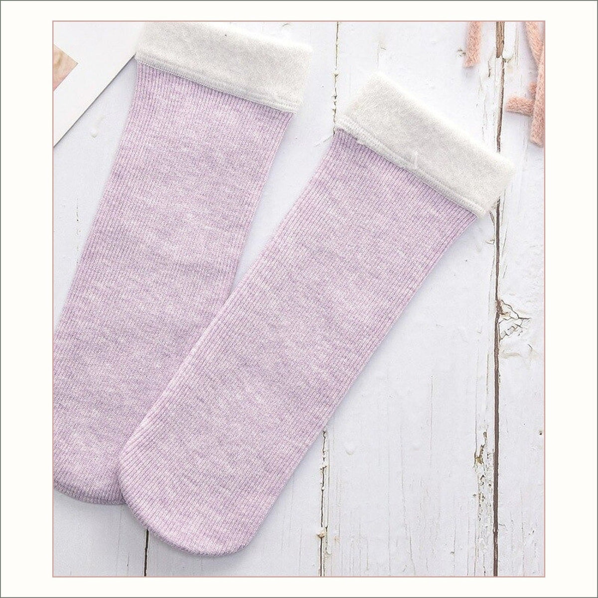Paire de chaussettes fourrées violettes à revers duveteux posée à plat