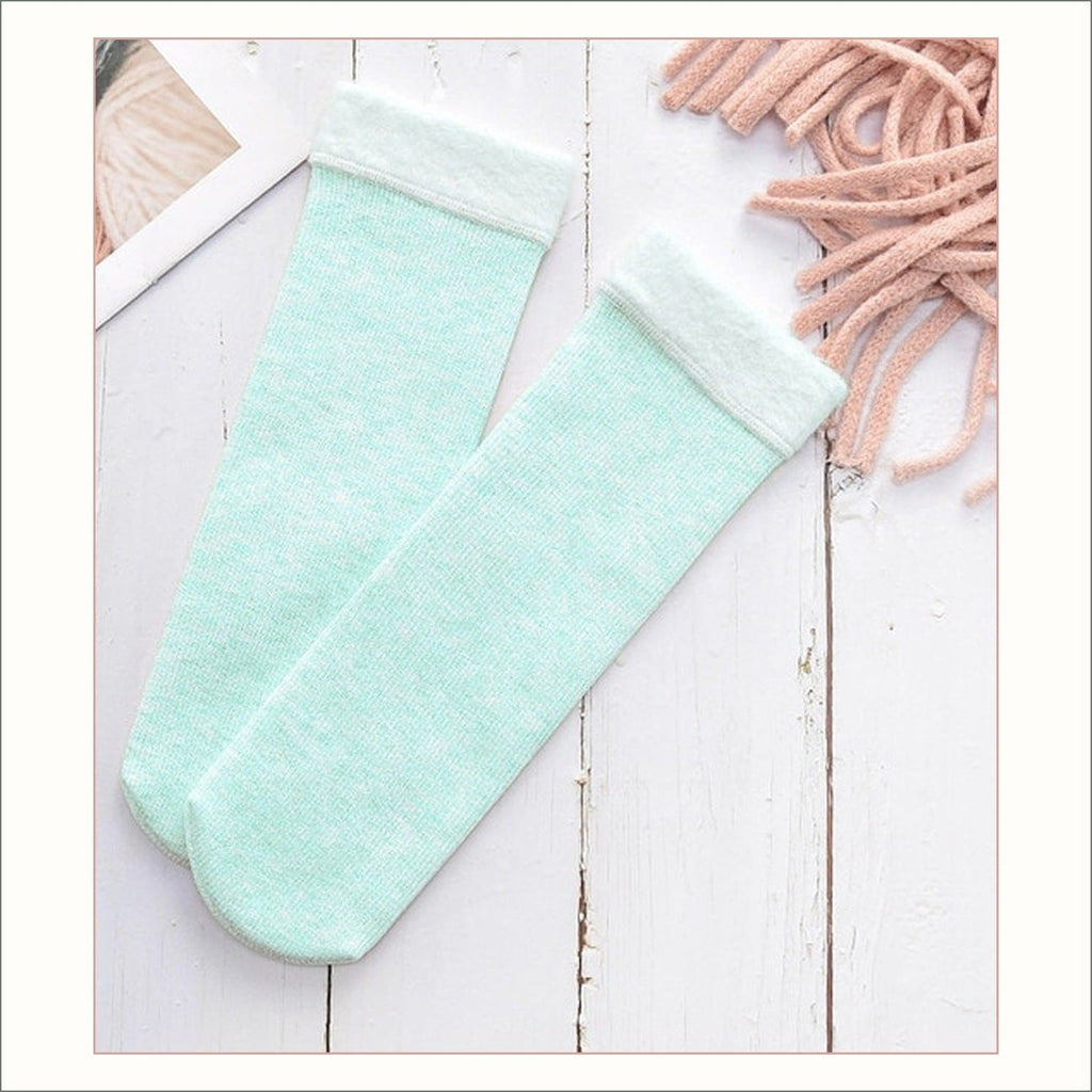 Paire de chaussettes fourrées vert d’eau à revers duveteux posée à plat