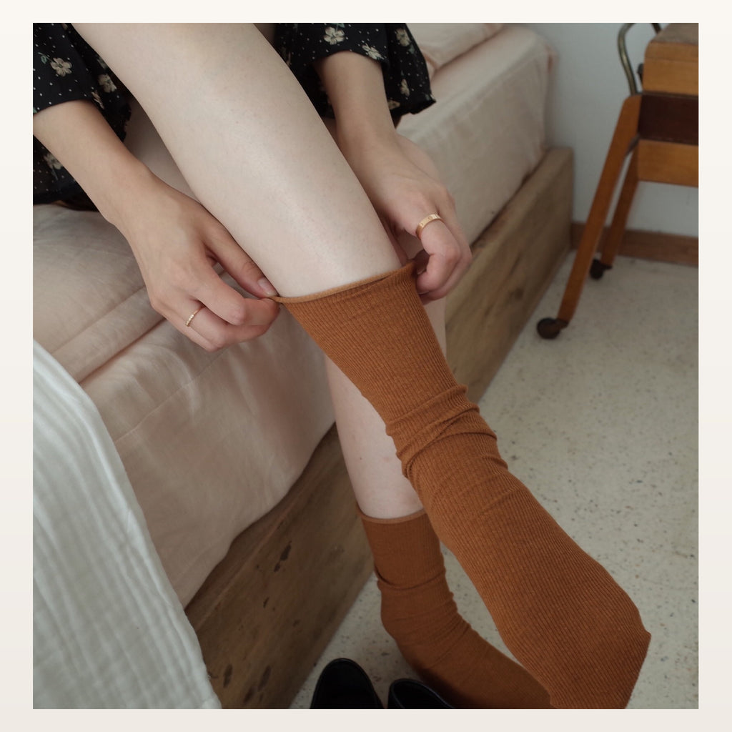 Chaussettes longues unies orange enfilées dans une chambre