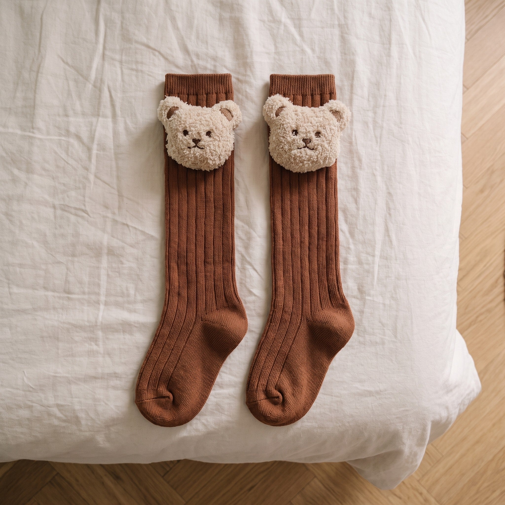 Chaussettes montantes camel dépliées sur toute leur longueur sur un lit d'enfant Image