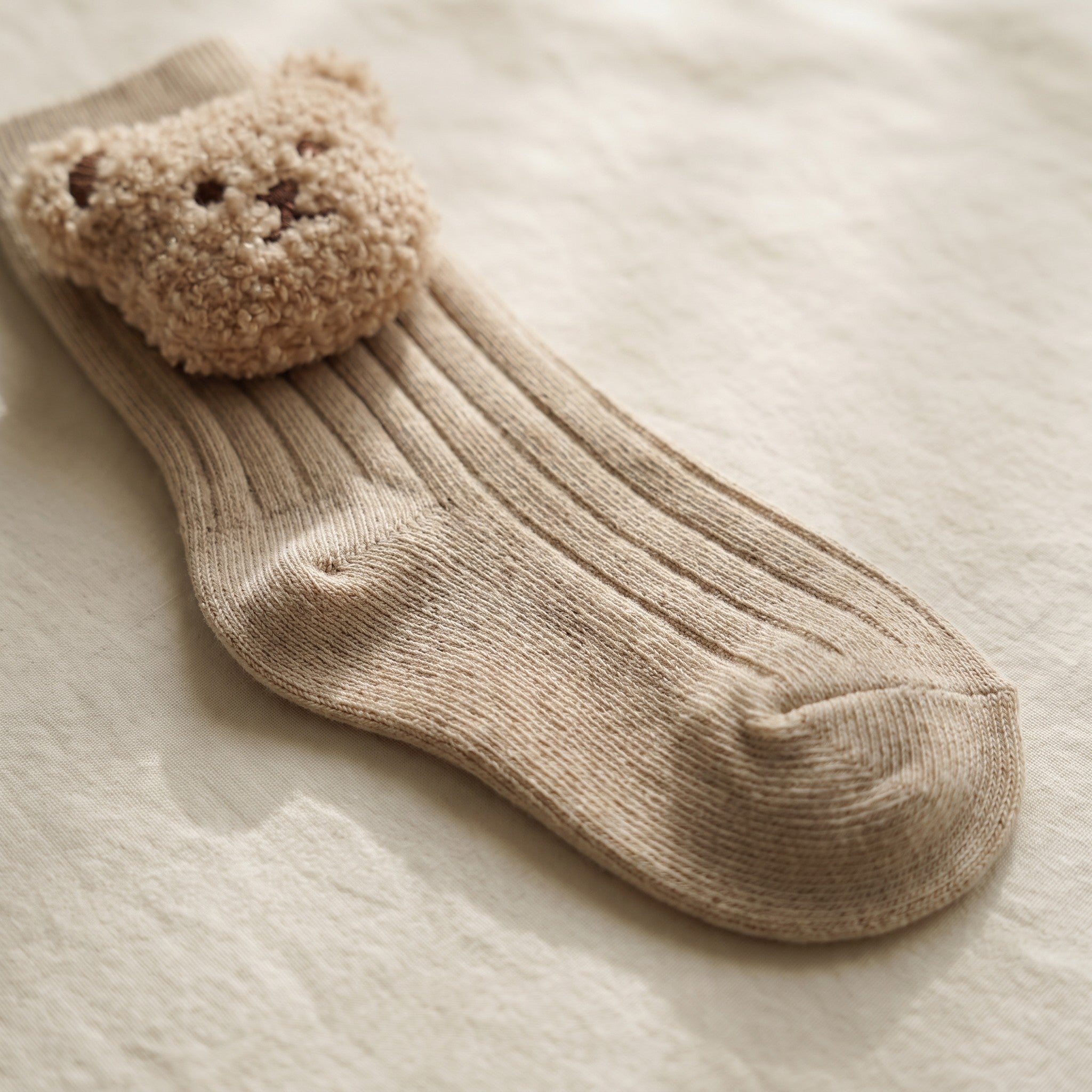 Le pied et la maille de coton côtelée d'une chaussette montante beige pour bébé Image
