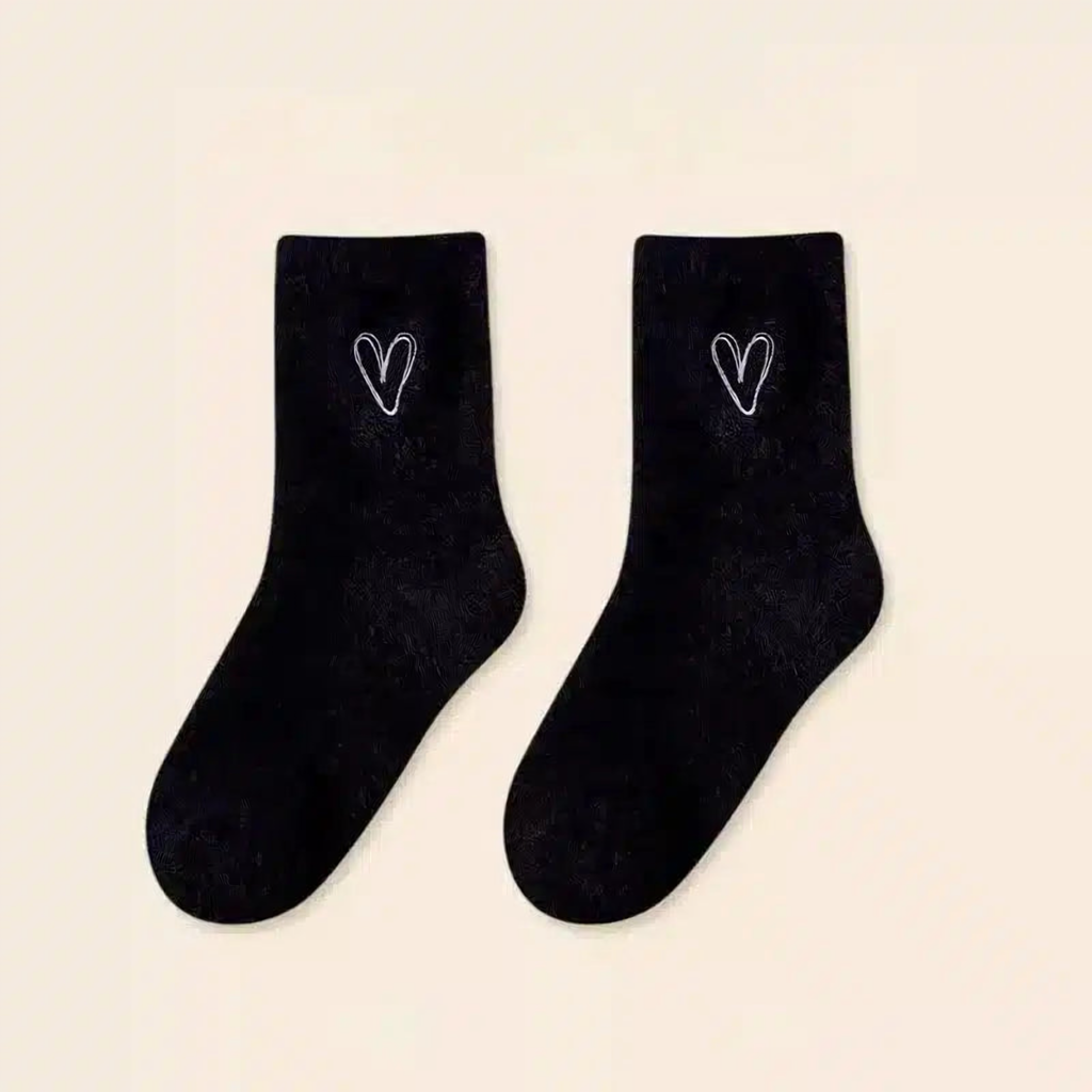 Une paire de chaussettes peluche noires à cœur brodé blanc