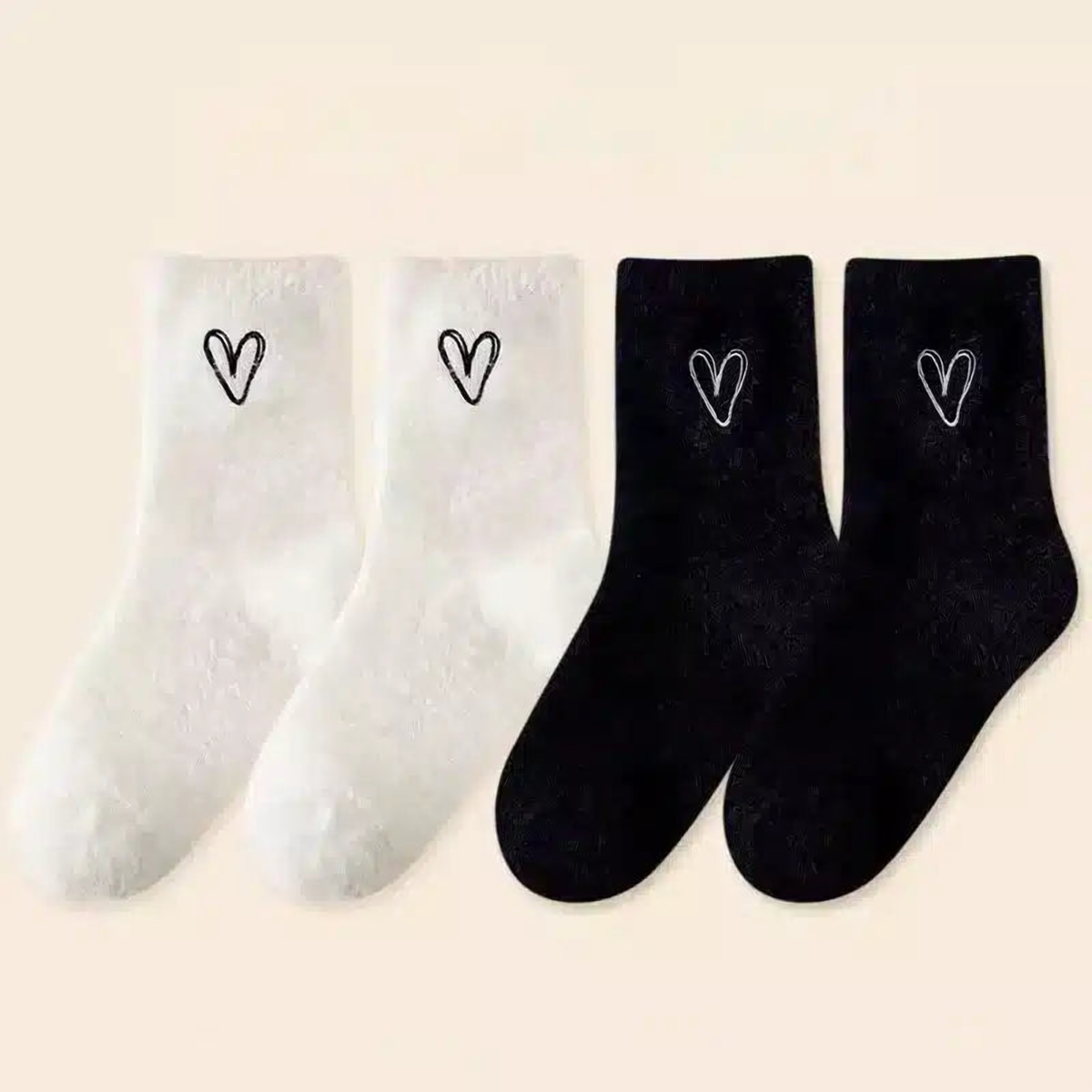 Deux paires de chaussettes peluche à cœur brodé, une noire et une blanche