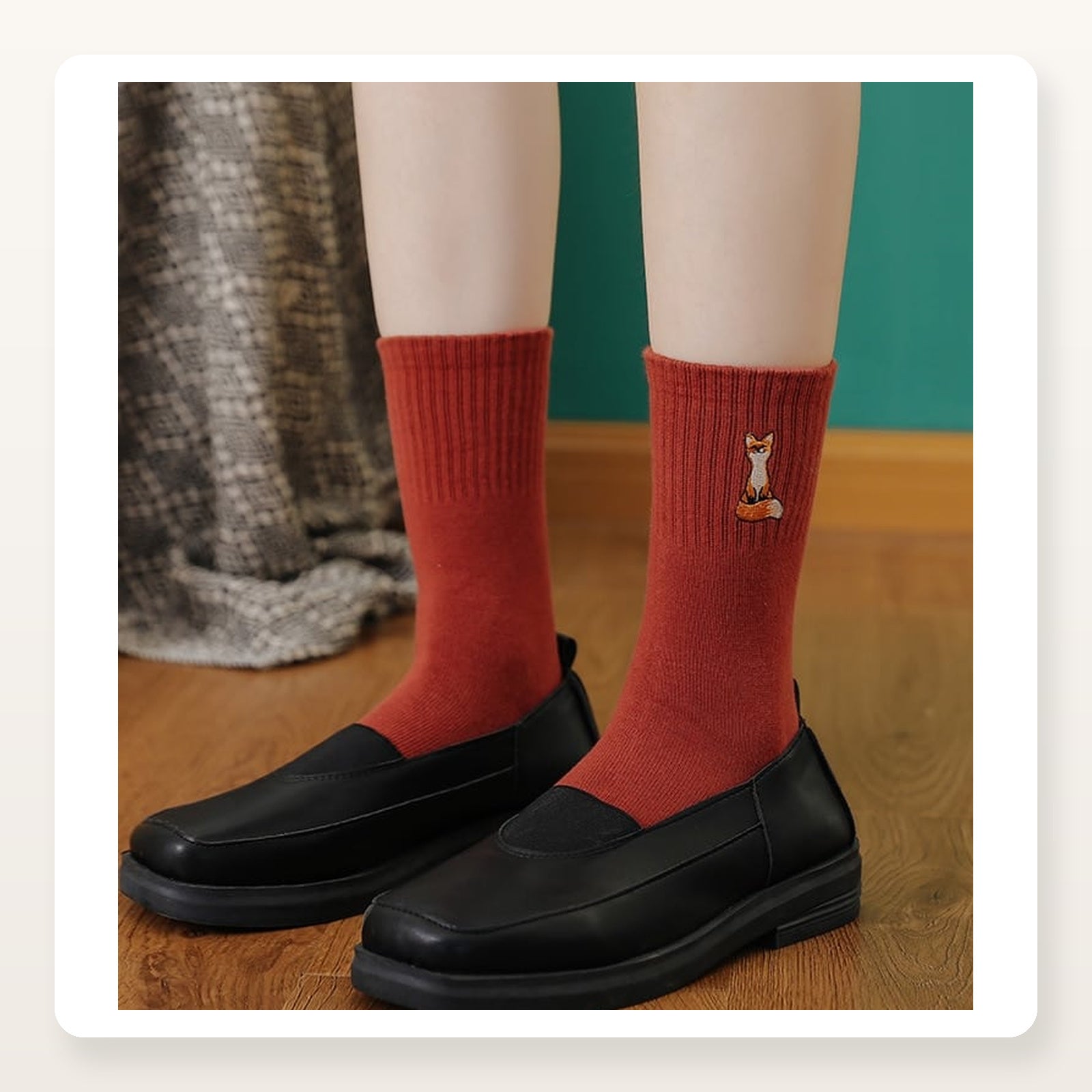 Chaussettes rouges à renard brodé portées dans un intérieur chaleureux Image