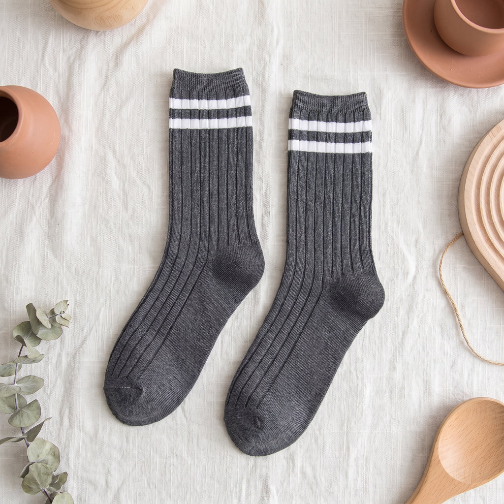 Chaussettes américaines gris foncé à deux rayures blanches sur fond lin
