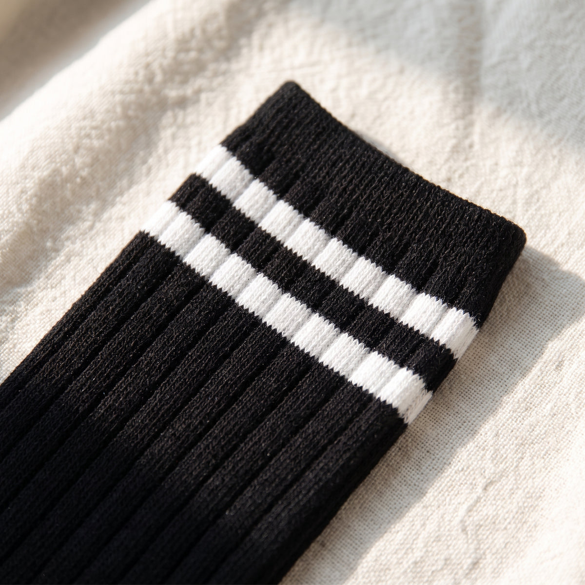 Gros plan sur les côtes et les deux rayures blanches d'une chaussette américaine noire Image