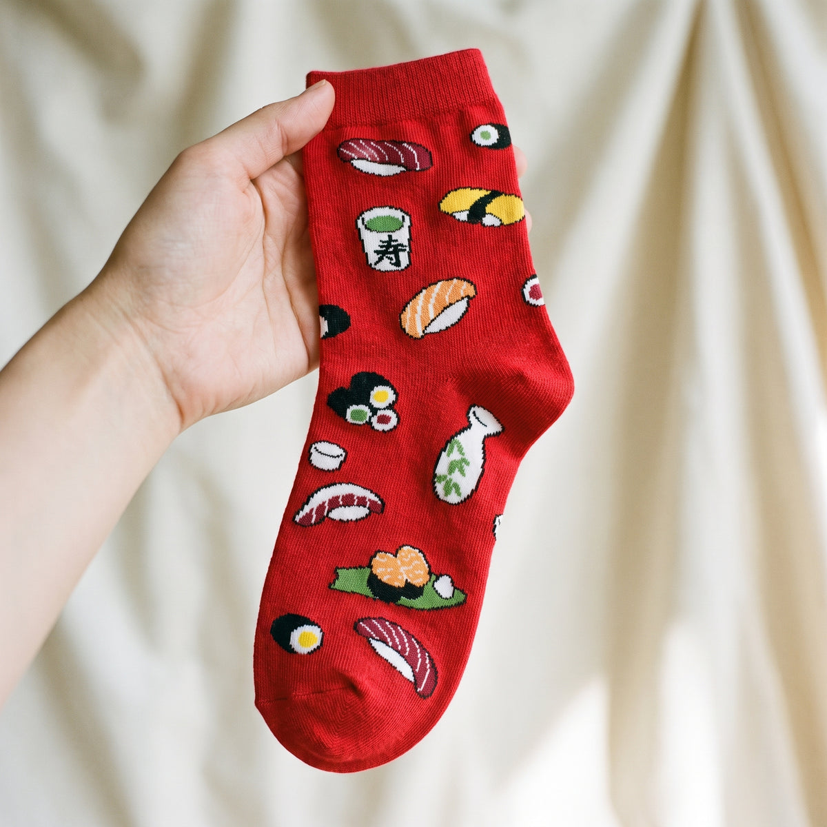Detail de la maille et du motif sushi sur une chaussette rouge Image