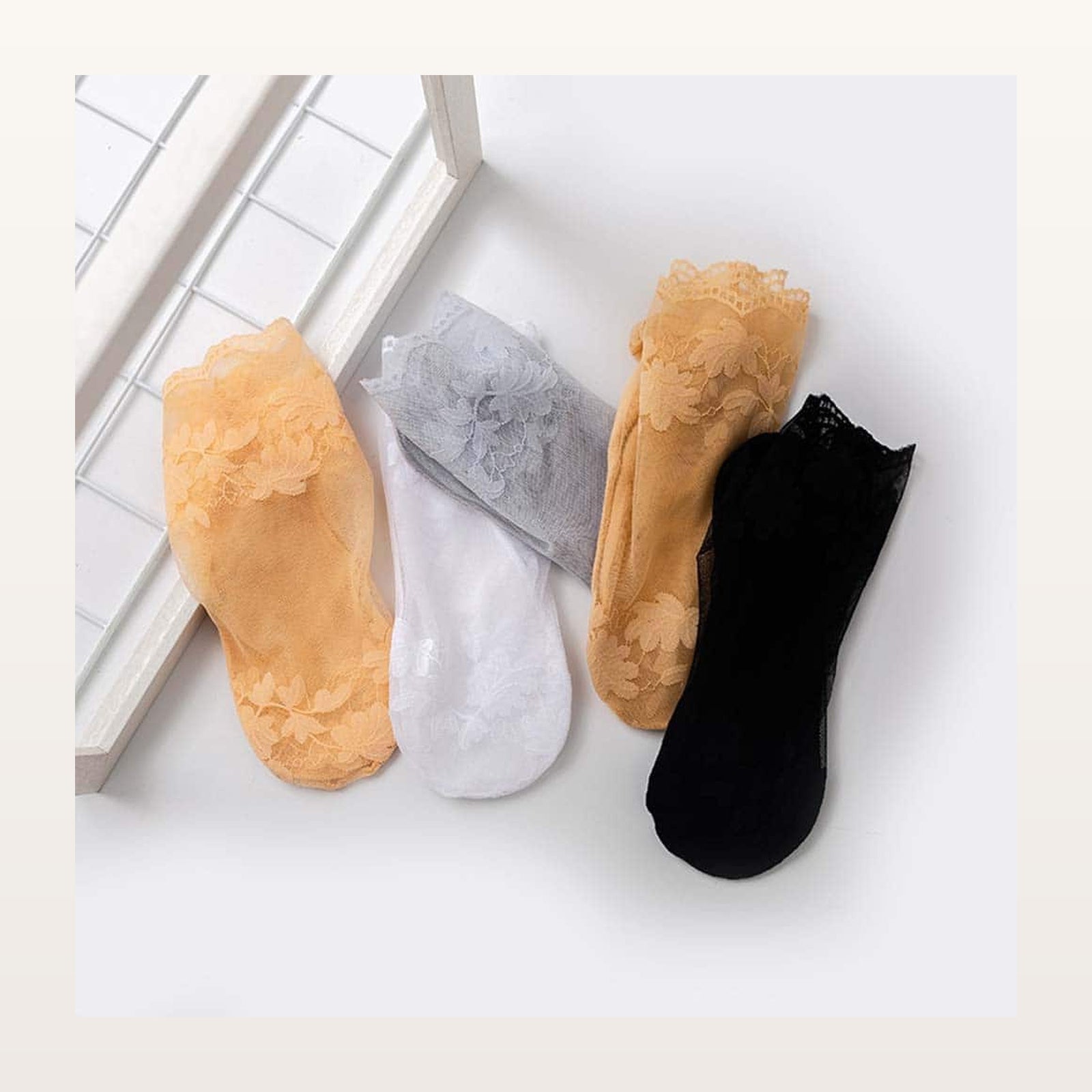 Cinq chaussettes transparentes fleuries en beige, gris, blanc, jaune et noir Image