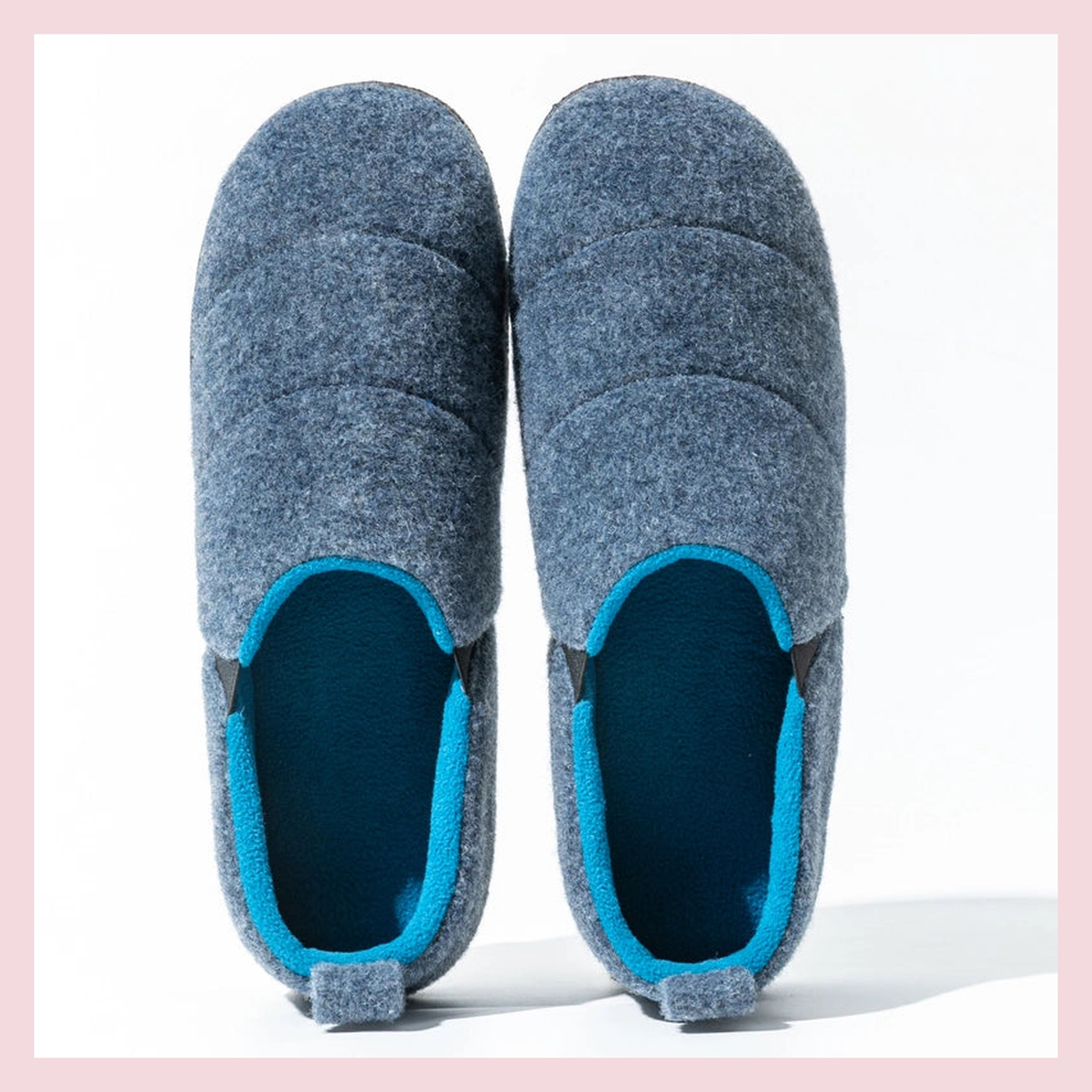Deux chaussons homme bleu marine aux coutures identiques portés dans une chambre lumineuse Image