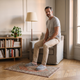 Homme du casting portant les chaussons gris dans le coin lecture, pieds ancrés sur le tapis