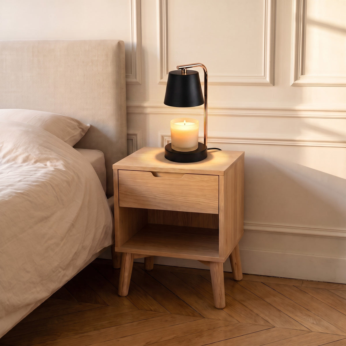 Chambre en fin de journée : la lampe chauffe-bougie noire allumée au chevet du lit est le seul point lumineux de la pièce Image