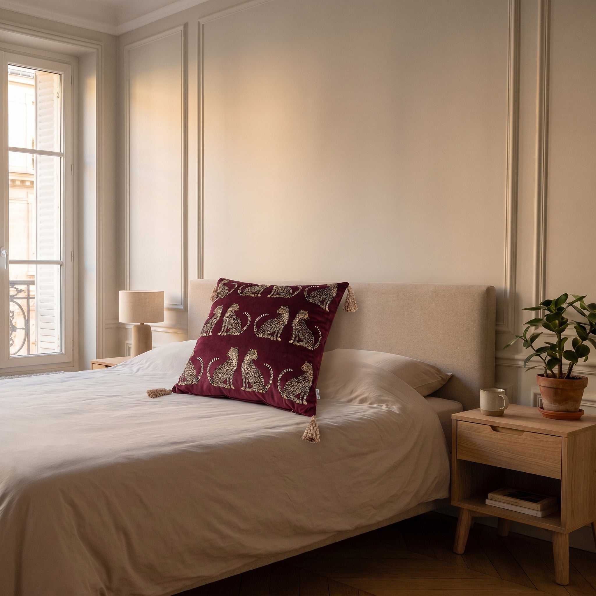 Housse de coussin léopard rouge bordeaux posée contre les oreillers d'un lit Image
