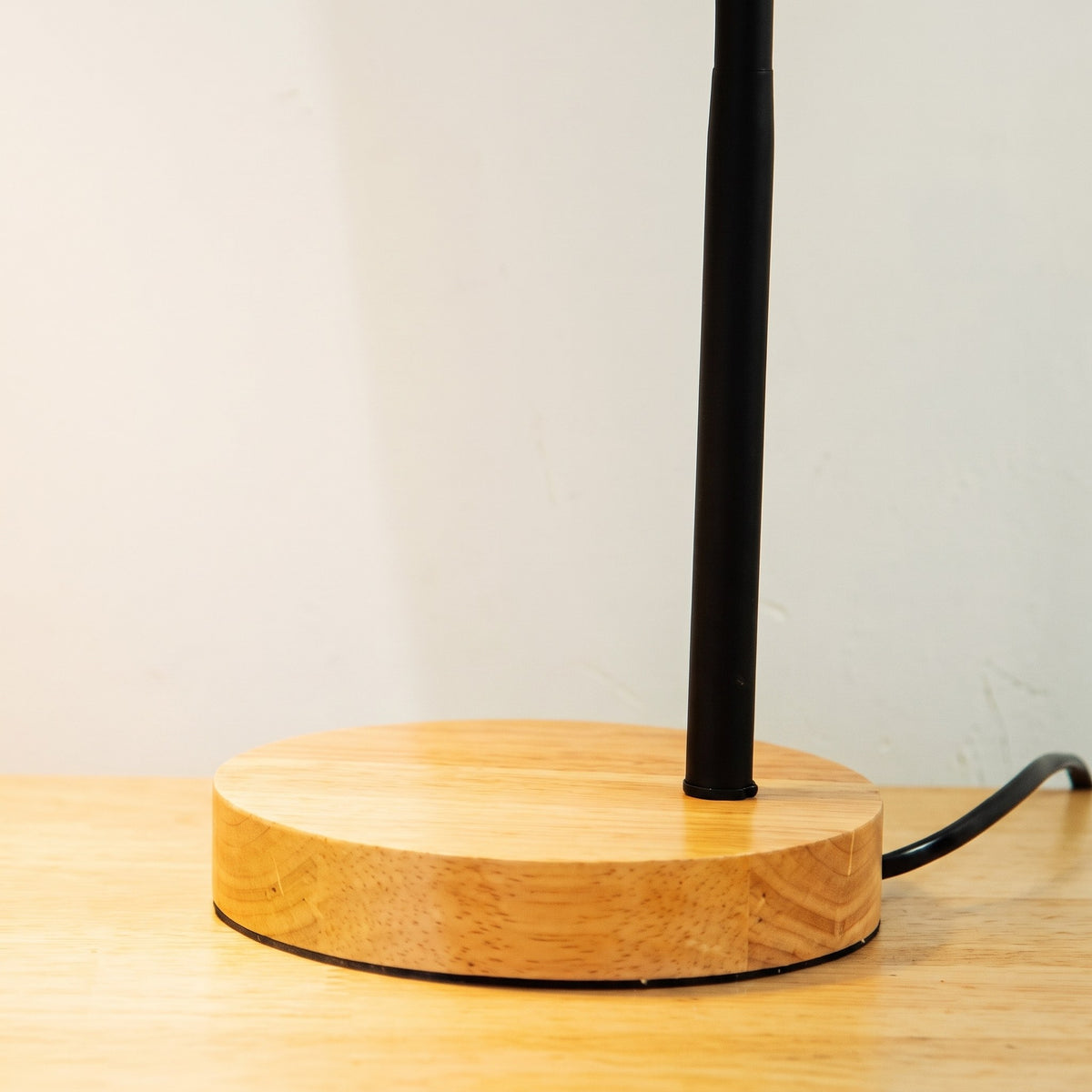 Le bras métallique s'élève du dessus du socle en bois Image