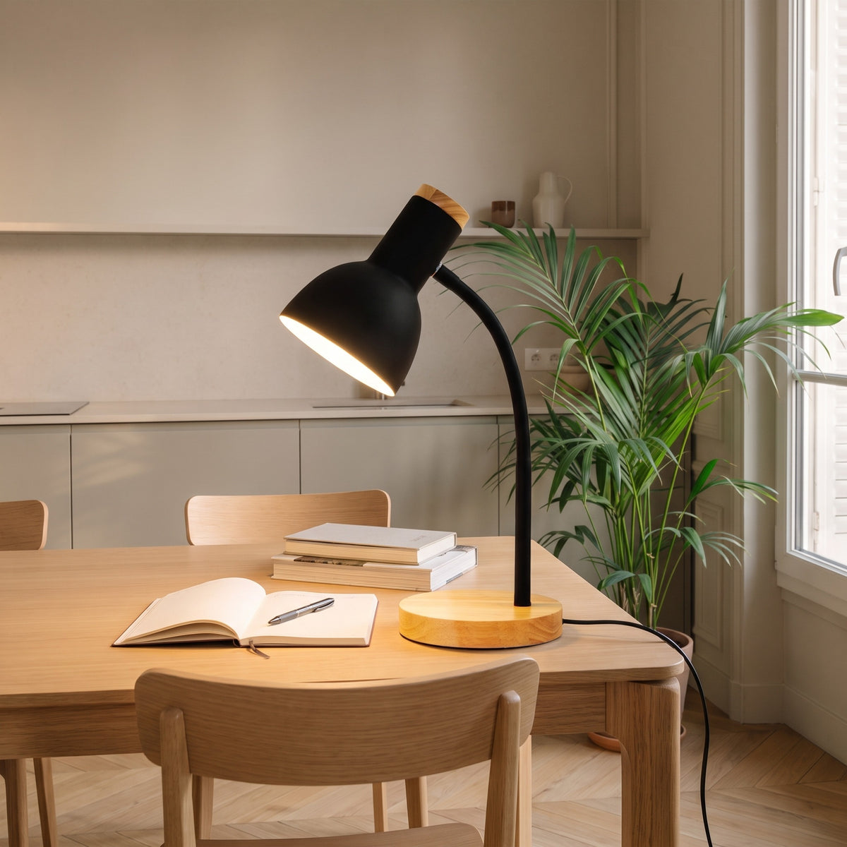 Lampe de bureau noire allumée au-dessus d'un cahier ouvert Image