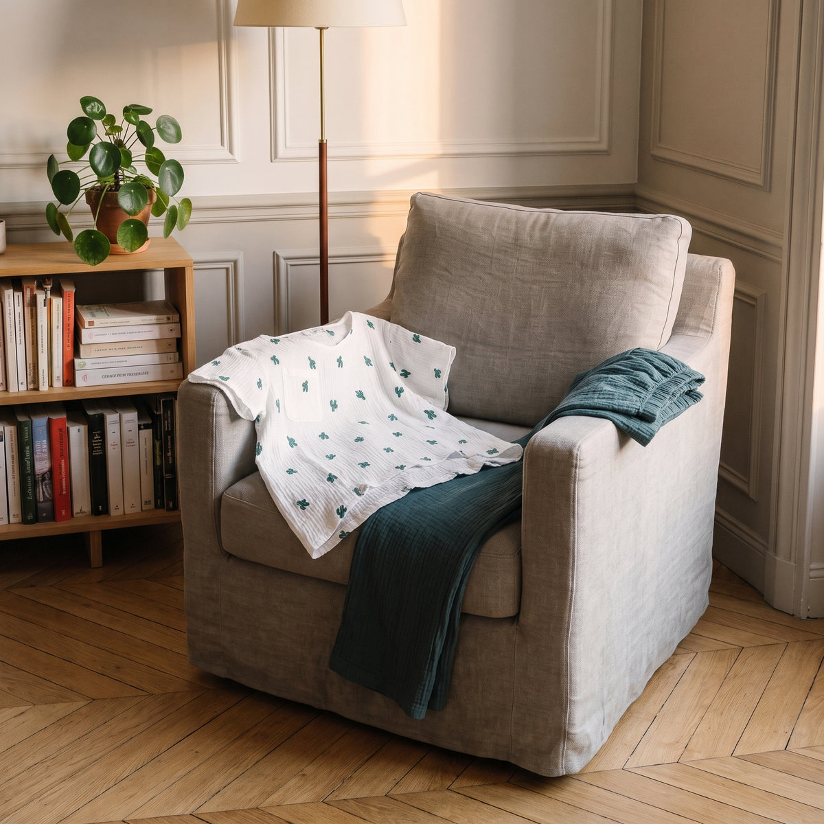 T-shirt blanc du pyjama plié sur un fauteuil, pantalon vert canard sur l'accoudoir Image