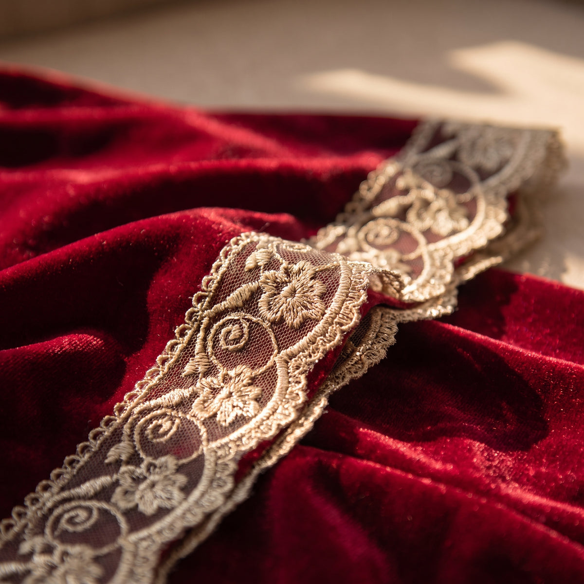Détail de la dentelle festonnée dorée sur le velours rouge Image