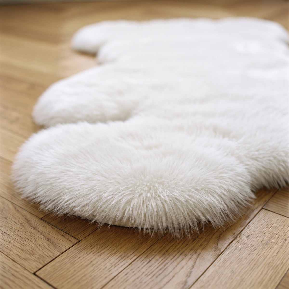 Gros plan du poil du tapis ourson blanc au bord du parquet Image