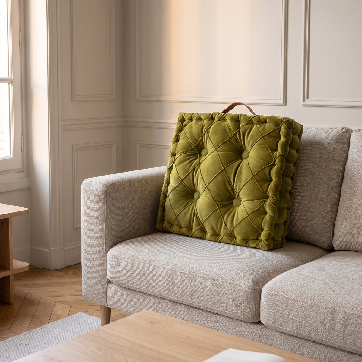 Coussin capitonne vert olive dans le canape