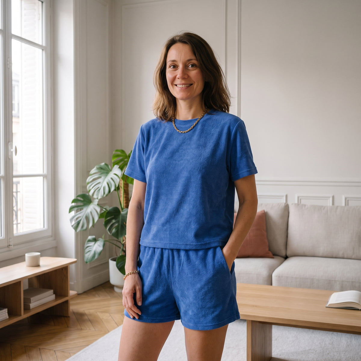 Ensemble d'été en éponge pour femme, coloris bleu roi, t-shirt et short portés dans un salon