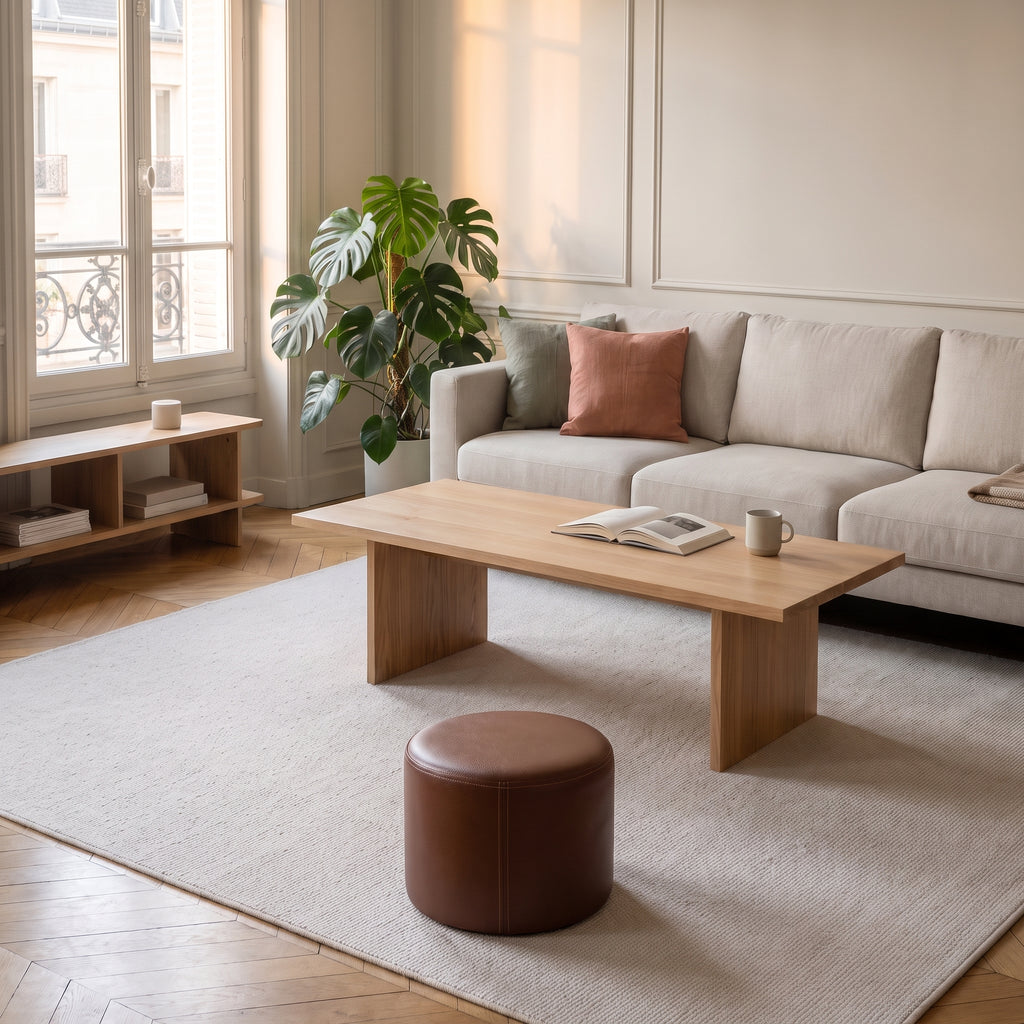 Pouf rond en cuir synthétique beige posé au sol