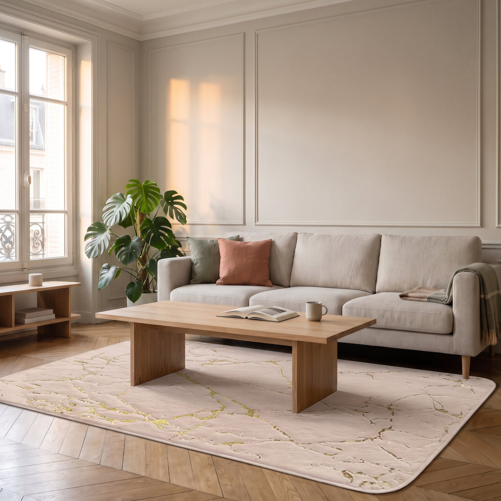 Tapis effet marbre beige rosé veiné d'or déployé sur le parquet en chevrons du salon