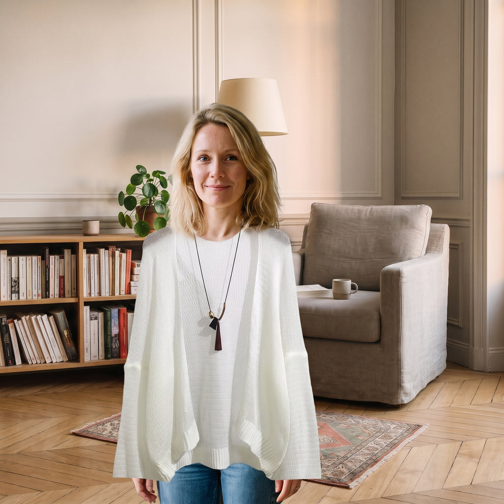 Cardigan blanc en maille ajourée porté dans un coin lecture