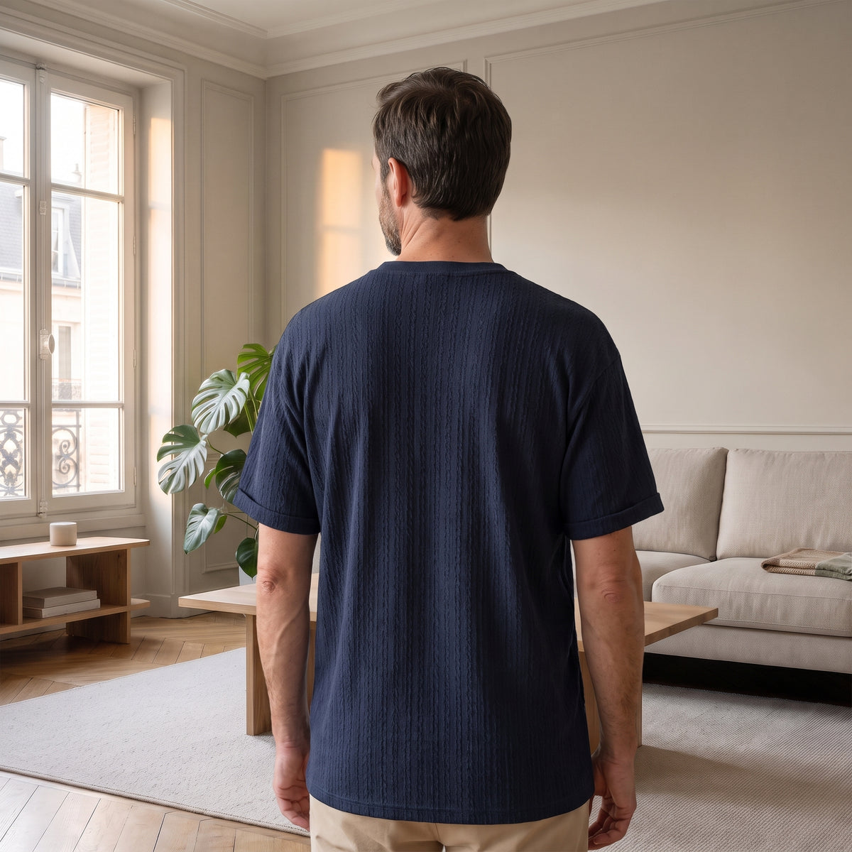 T-shirt maille torsadée bleu marine porté par un homme dans le salon