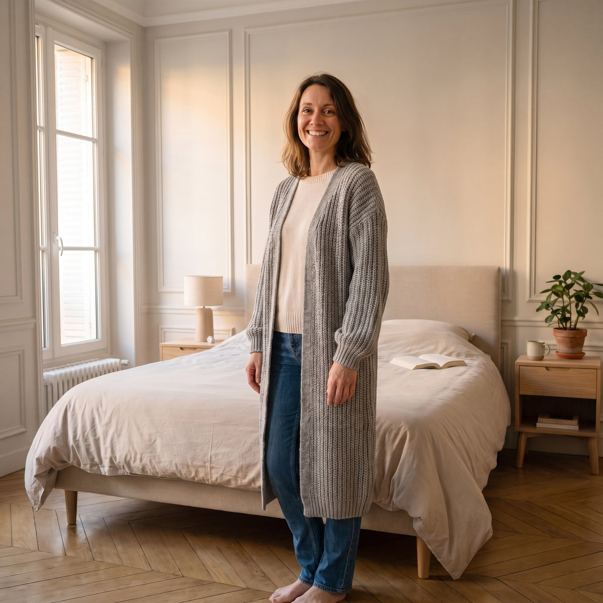 Cardigan long gris clair en côtes anglaises porté dans une chambre