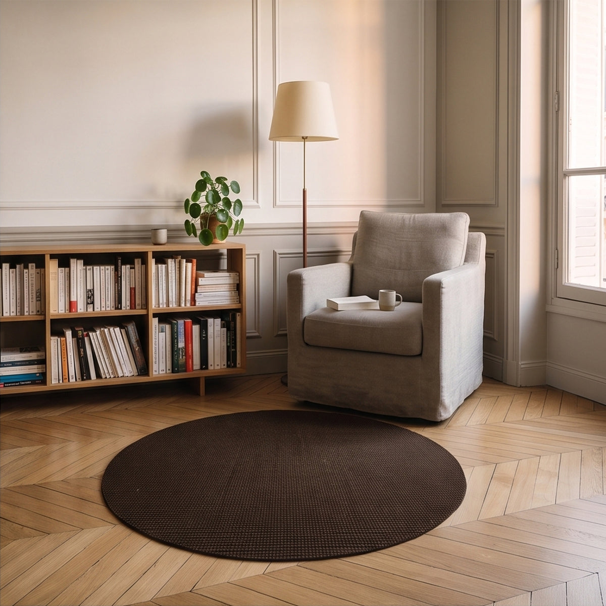 Tapis rond marron foncé en sisal posé dans un coin lecture