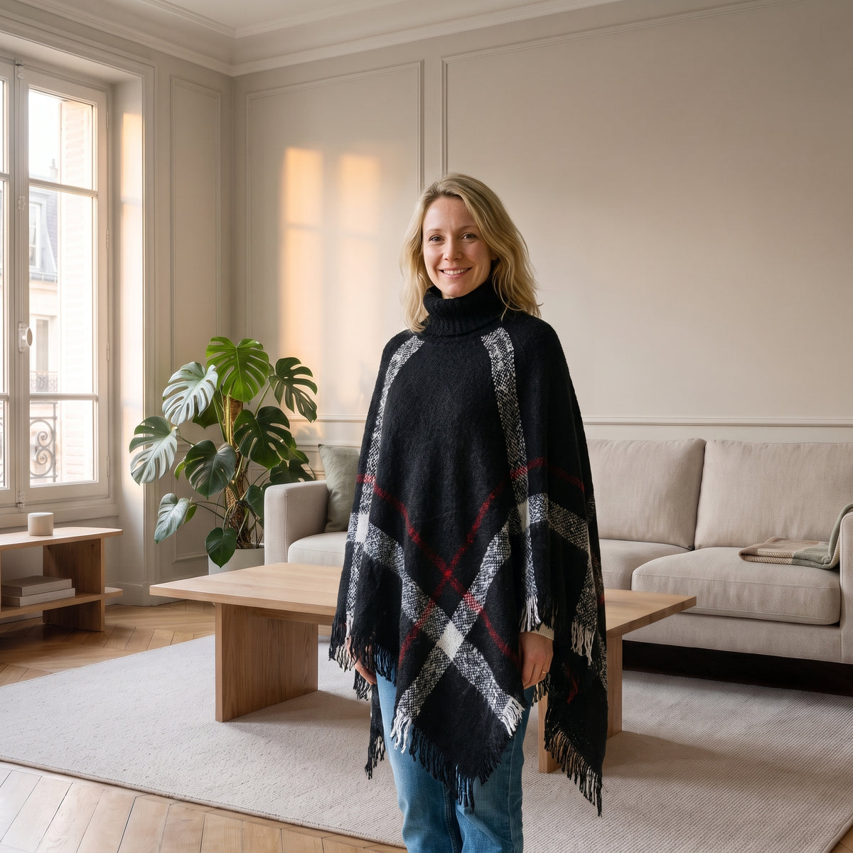 Cape femme noire à carreaux et col roulé portée dans le salon