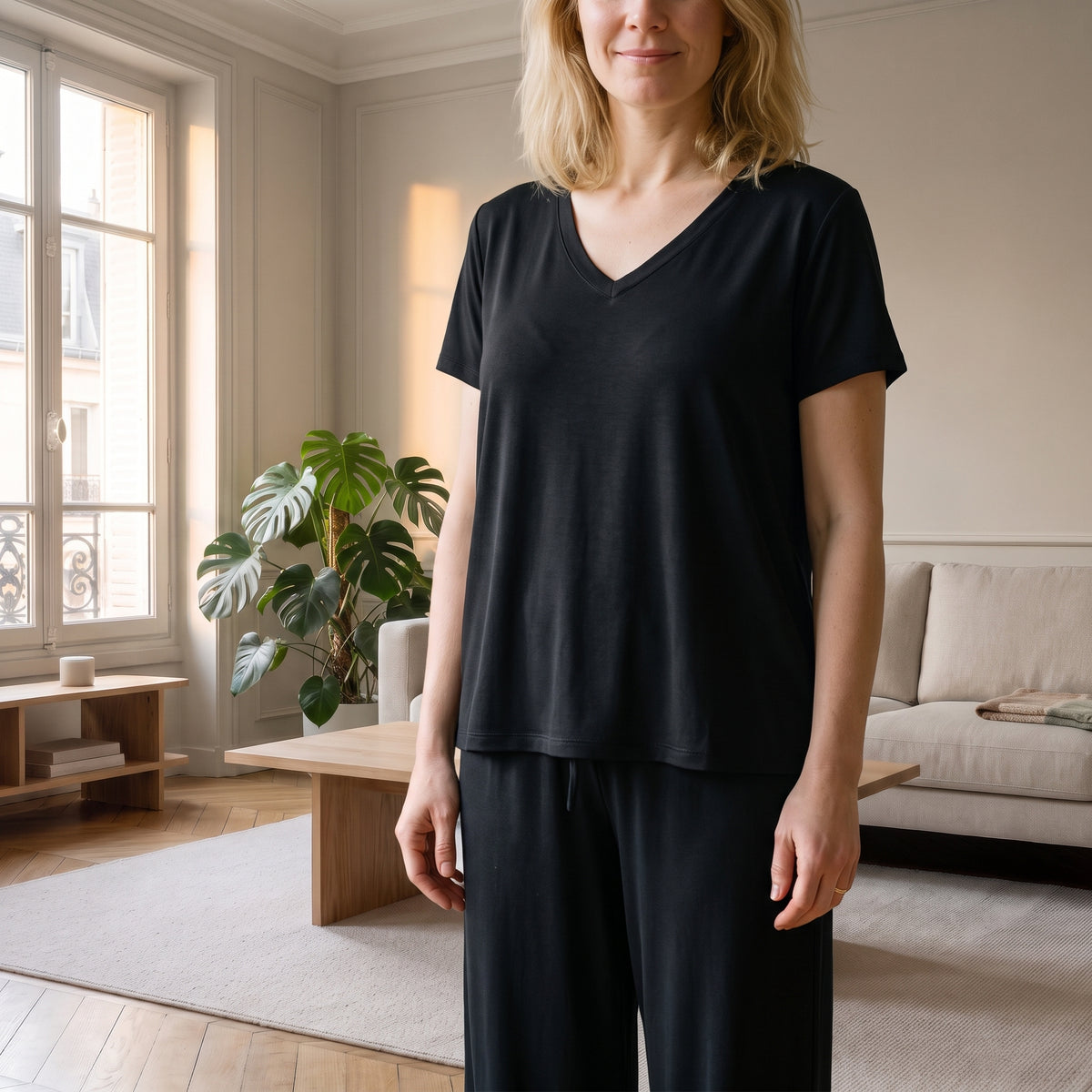 Pyjama mi-saison noir porté par une femme dans le salon