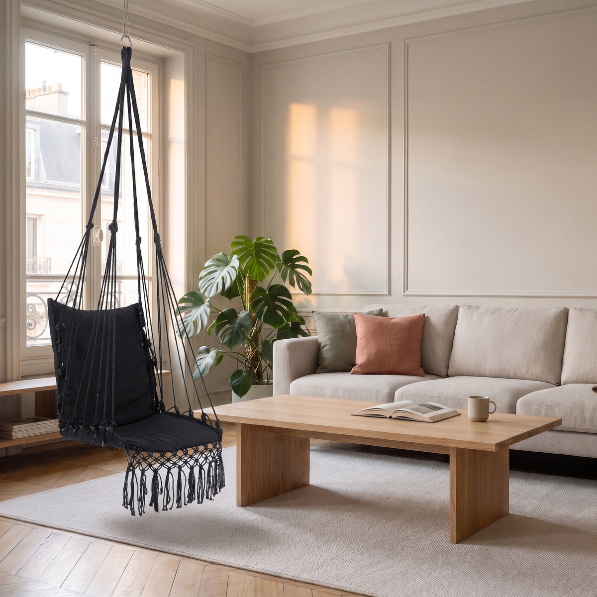 Chaise hamac noire en macramé suspendue dans un salon