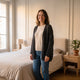 Cardigan noir en maille ajourée porté dans une chambre
