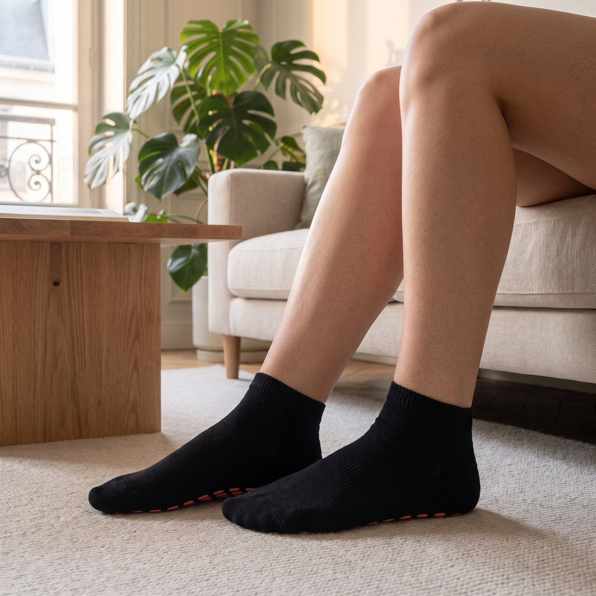 Chaussettes basses antiderapantes coloris noir, portees dans le salon