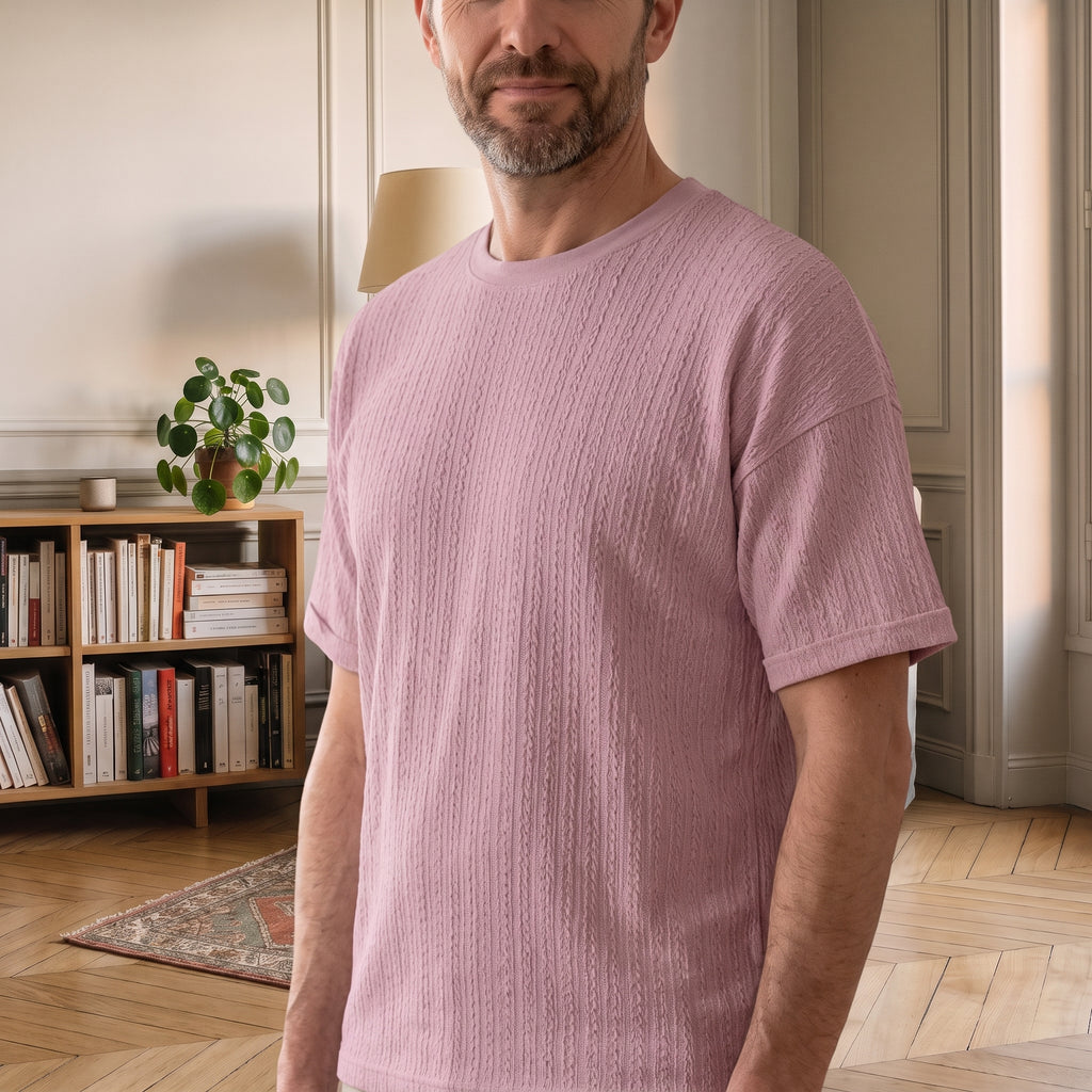 T-shirt maille torsadée rose porté par un homme dans un coin lecture