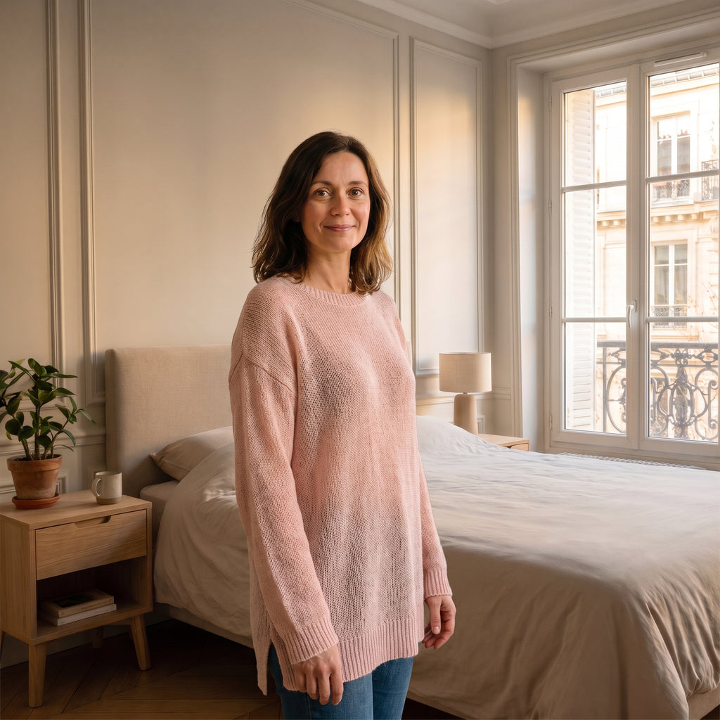 Cardigan rose en maille ajourée porté dans une chambre