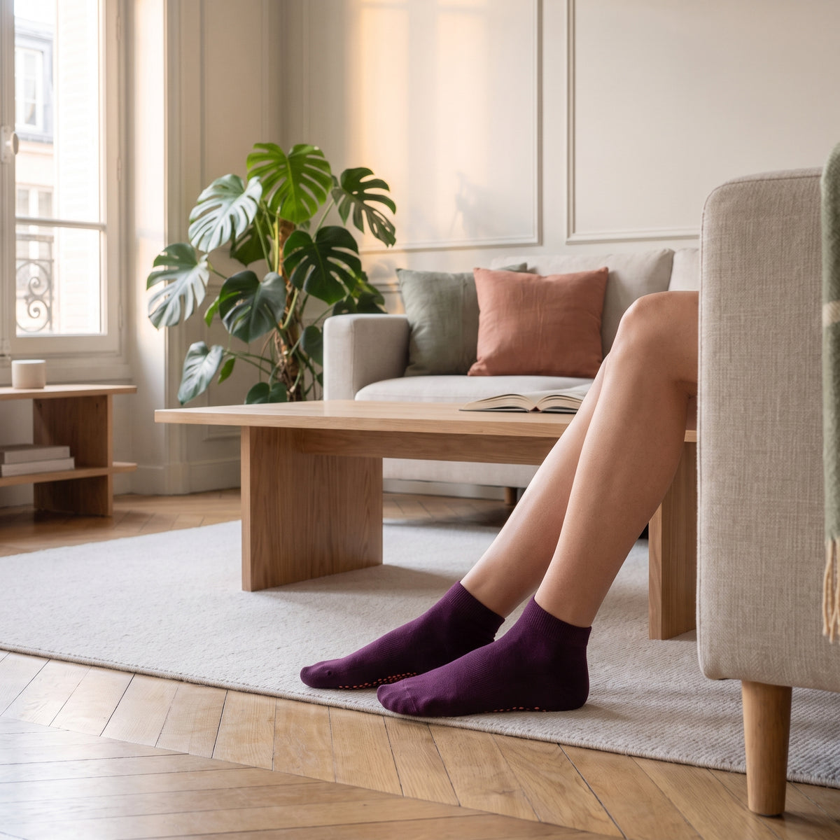 Chaussettes basses antiderapantes coloris violet foncé, portees dans le salon