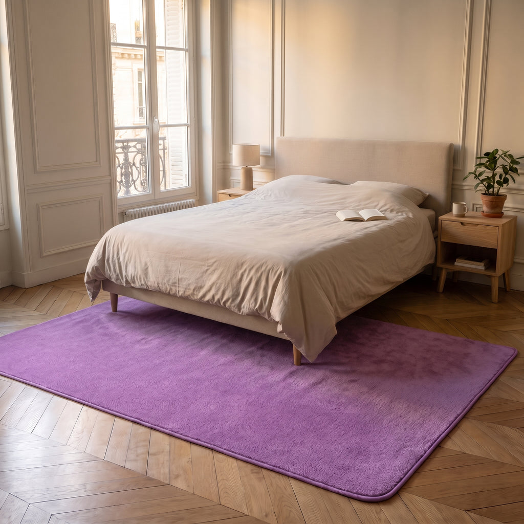 Tapis en molleton violet déployé au sol d'un salon, près d'un fauteuil