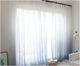Rideau tulle degrade gris ferme devant une fenetre entiere