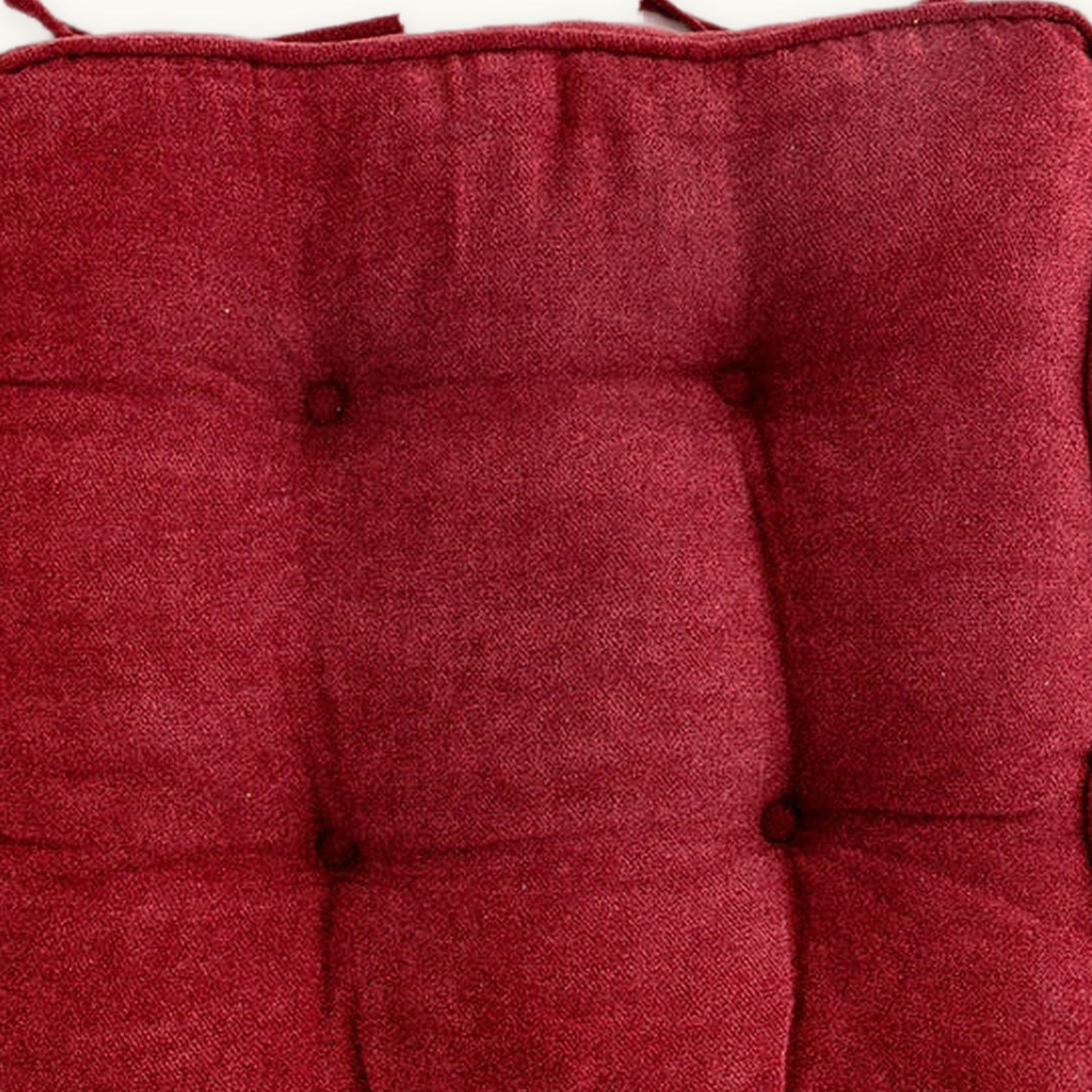 Détail du pourtour et des liens du coussin carré rouge capitonné Image