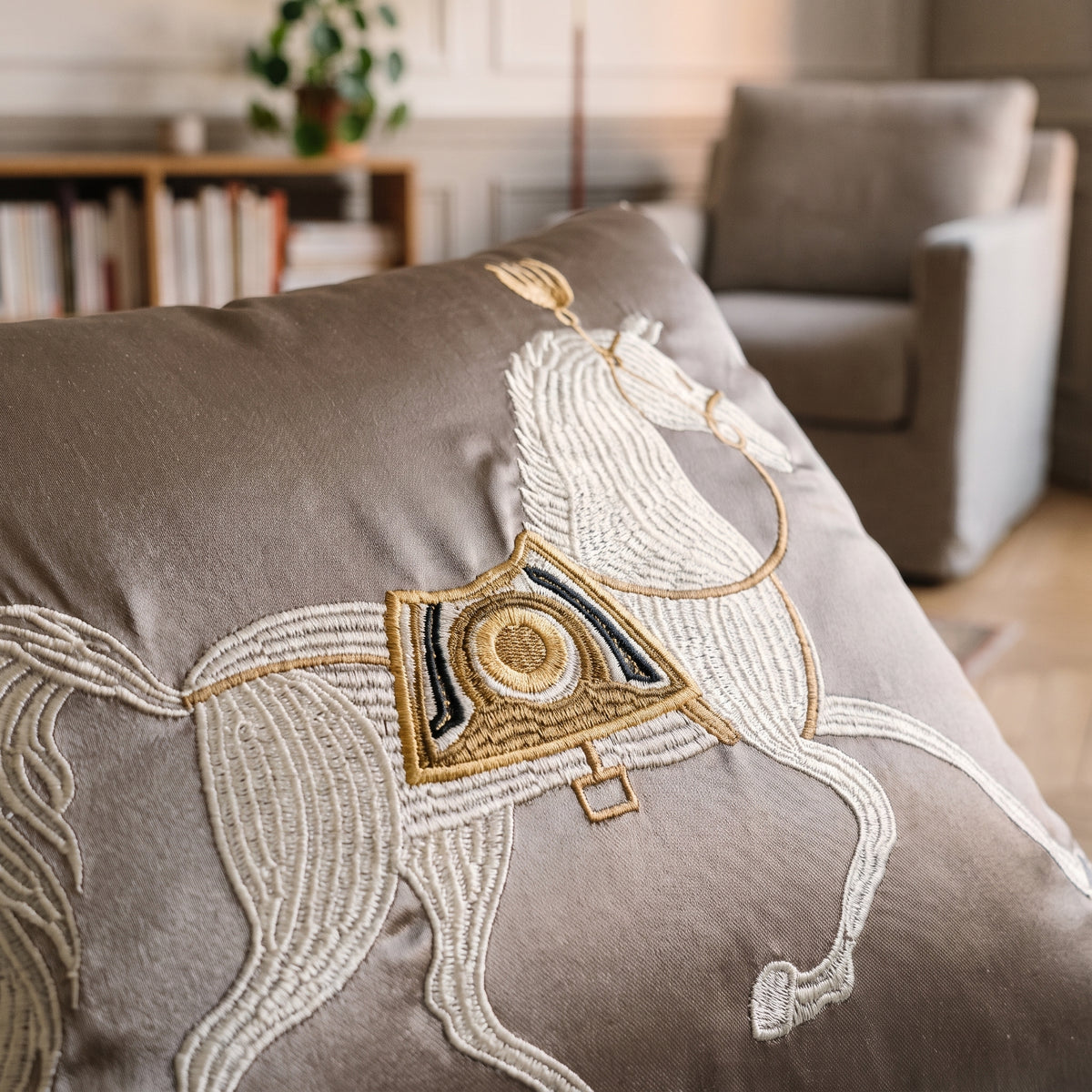 Détail de la broderie et du satin du coussin gris au cheval blanc