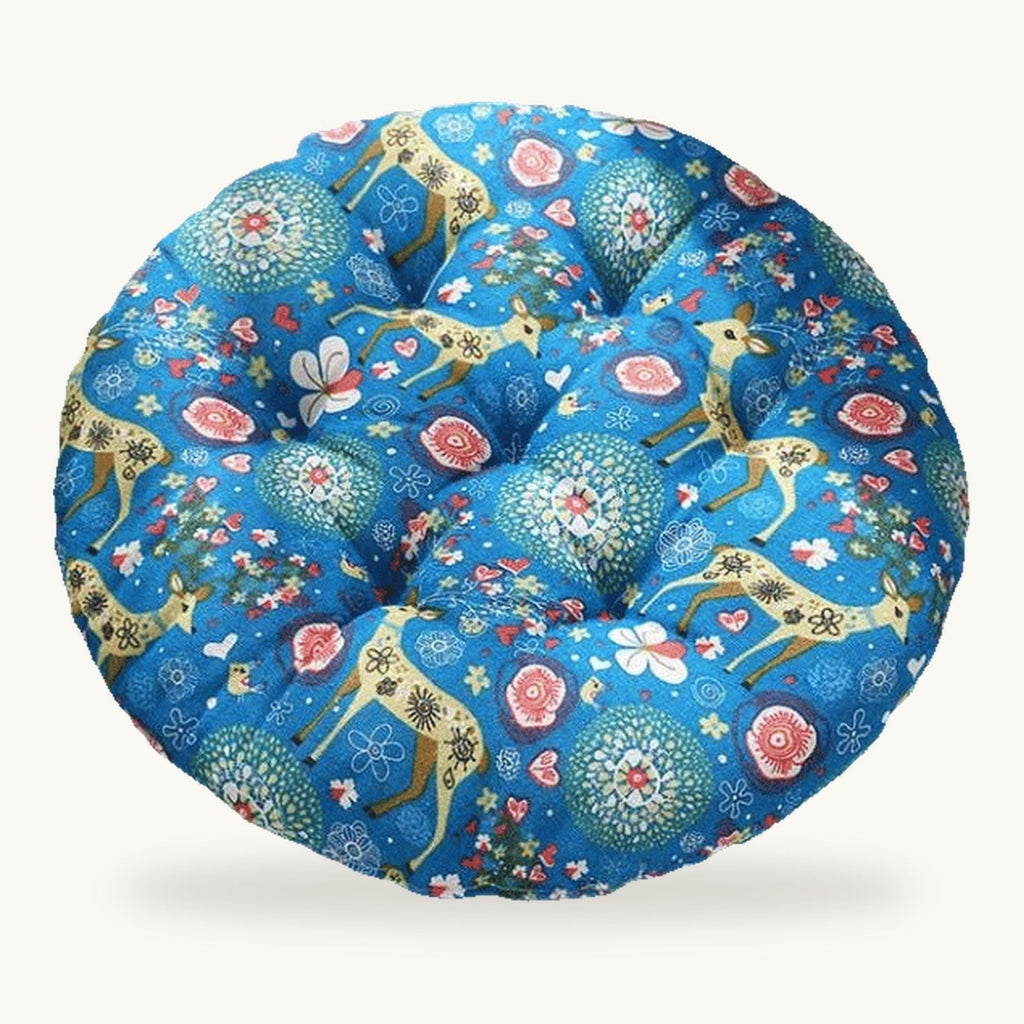 Coussin de sol rond capitonné à motif floral et animalier sur fond bleu sur fond clair
