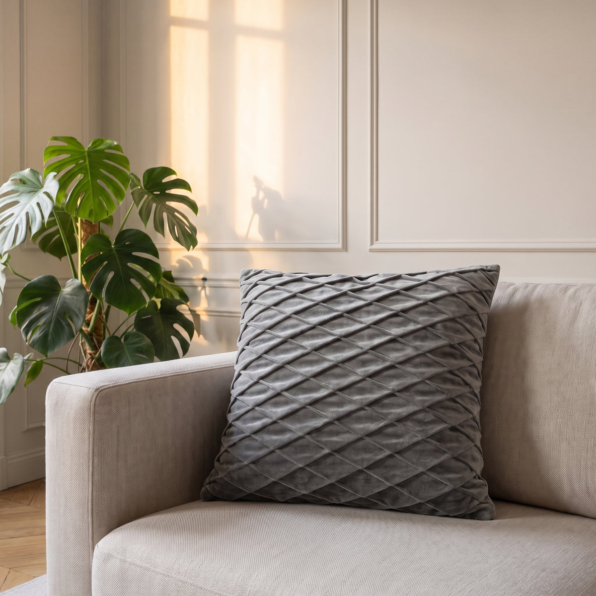Housse de coussin en velours gris posée contre l'accoudoir d'un canapé Image