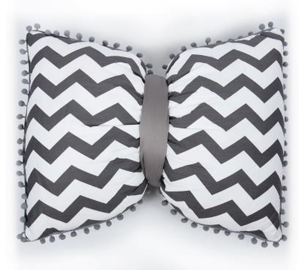 Coussin nœud papillon à chevrons gris, posé sur un canapé gris