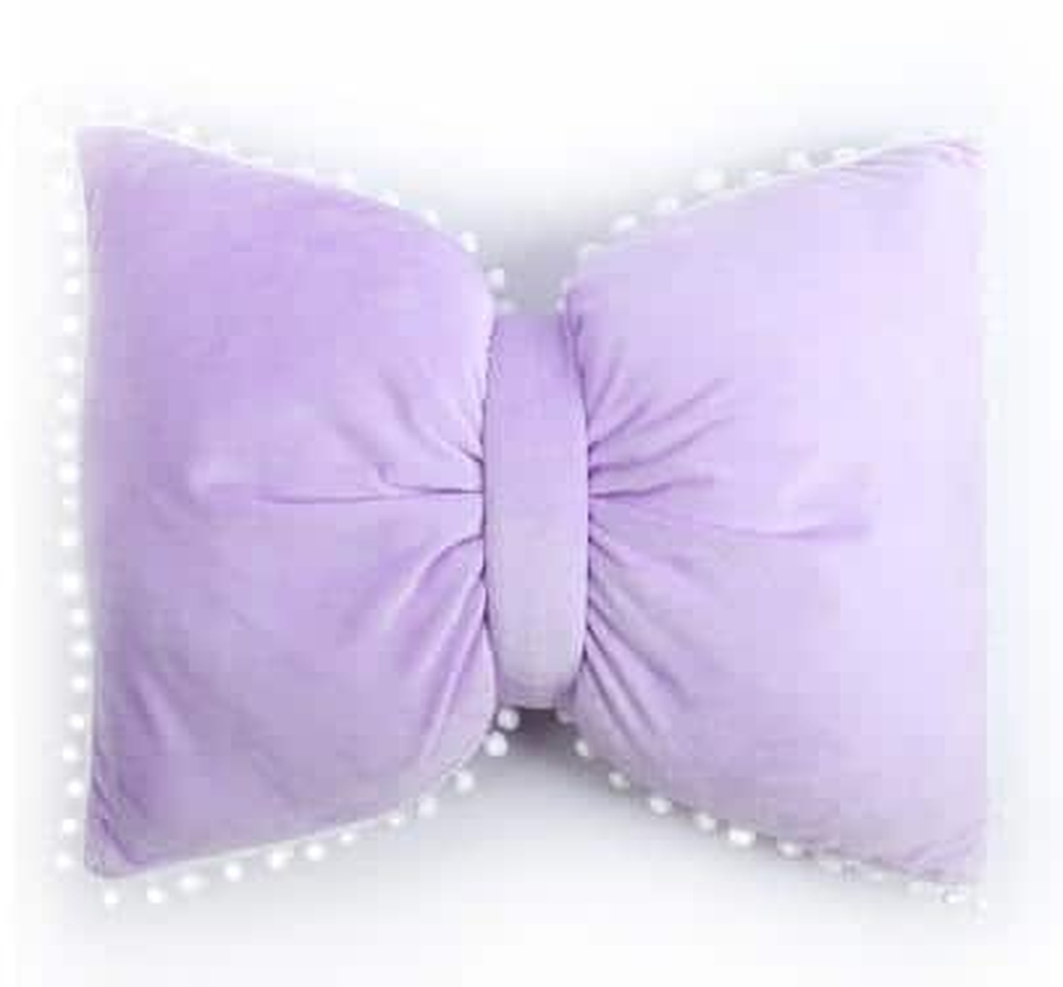 Coussin nœud papillon violet, posé sur un canapé gris