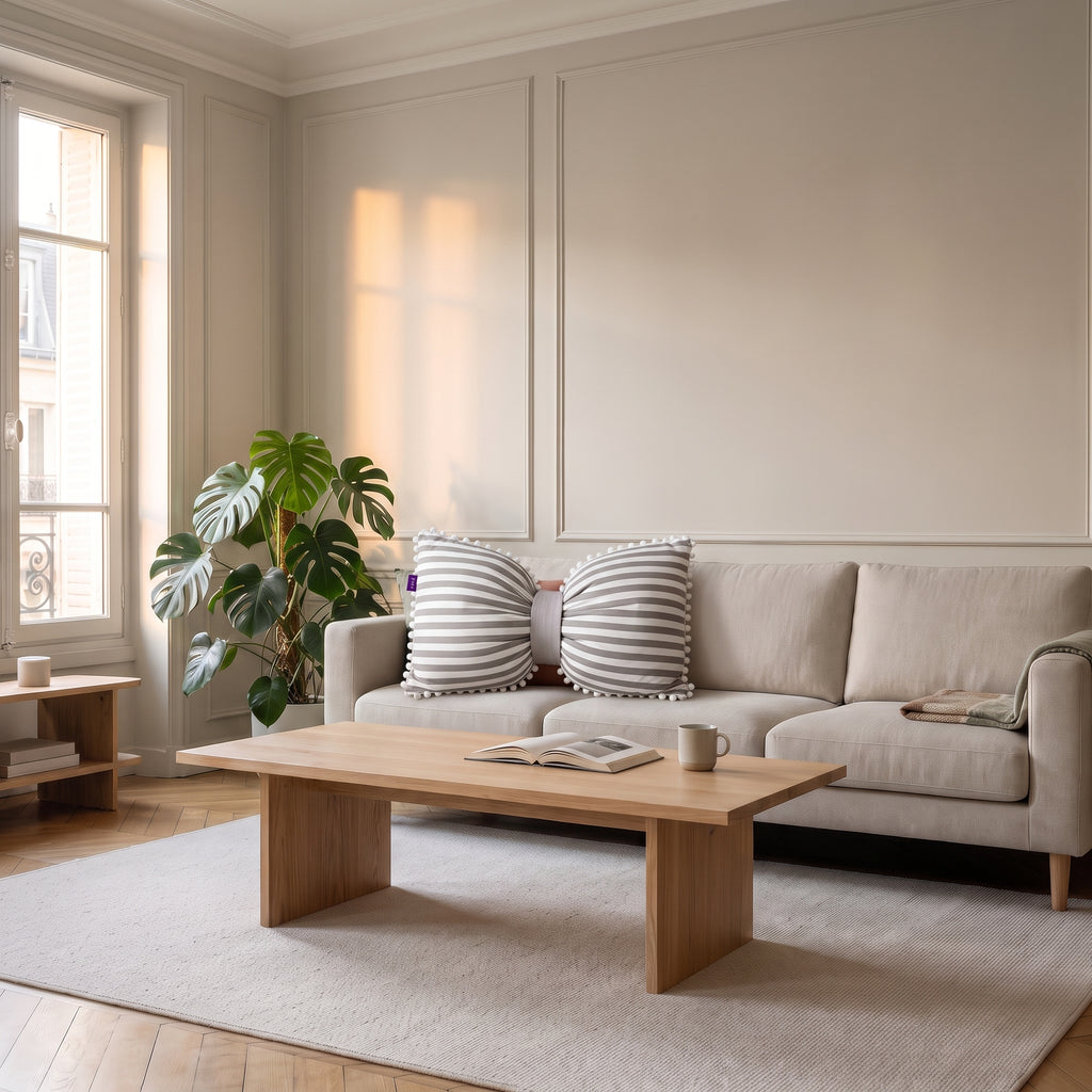 Coussin nœud papillon blanc à rayures grises sur un canapé clair