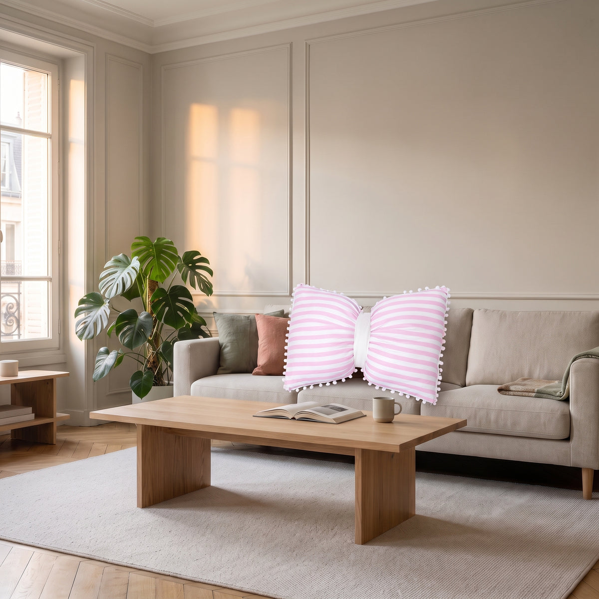 Coussin nœud papillon à rayures roses sur un canapé clair