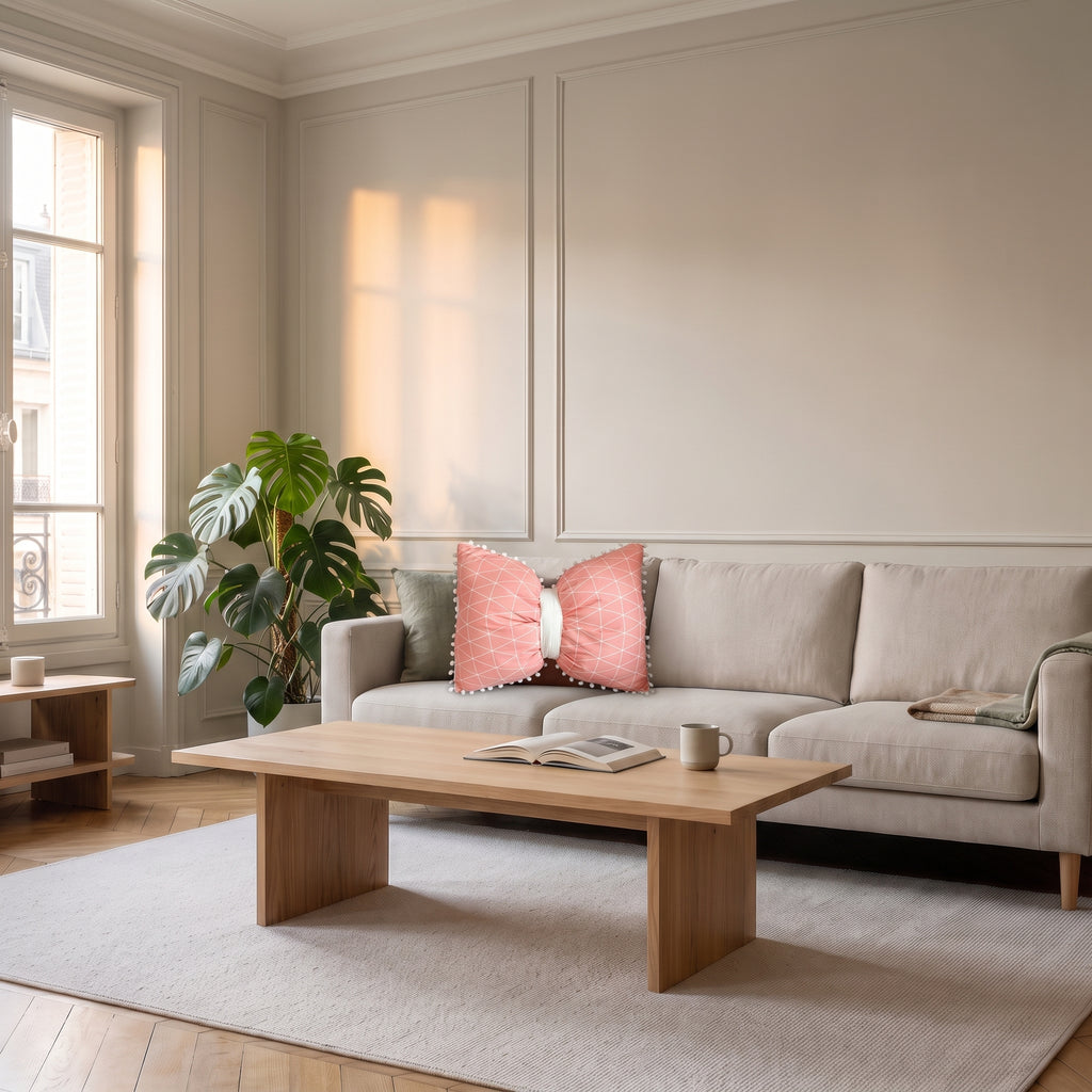 Coussin nœud papillon rose à motif géométrique sur un canapé clair